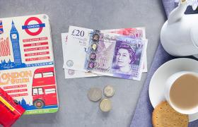 Pound notes, cup of tea and London guide book